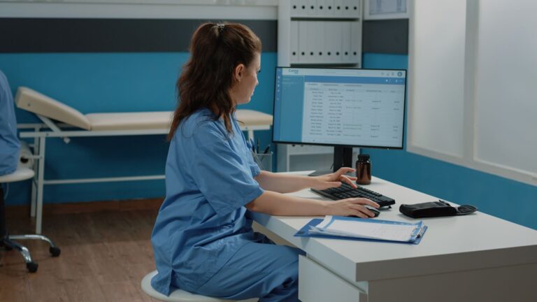 woman-working-as-nurse-with-computer-and-documents-2021-12-09-06-11-16-utc